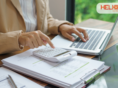 Professional reviewing website development costs and financial documents using a calculator and laptop at a modern workspace, representing budgeting and planning for WordPress website development in India.